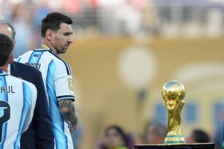 lionel-messi-com-a-camisa-da-selecao-argentina-ao-lado-do-trofeu-da-copa-do-mundo.